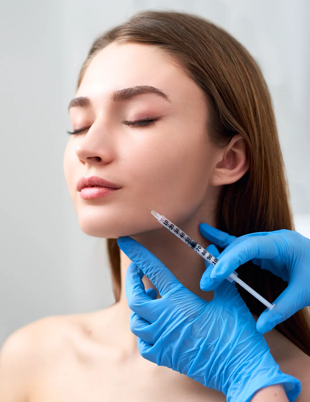 A woman receiving dermal filler injections in her face.