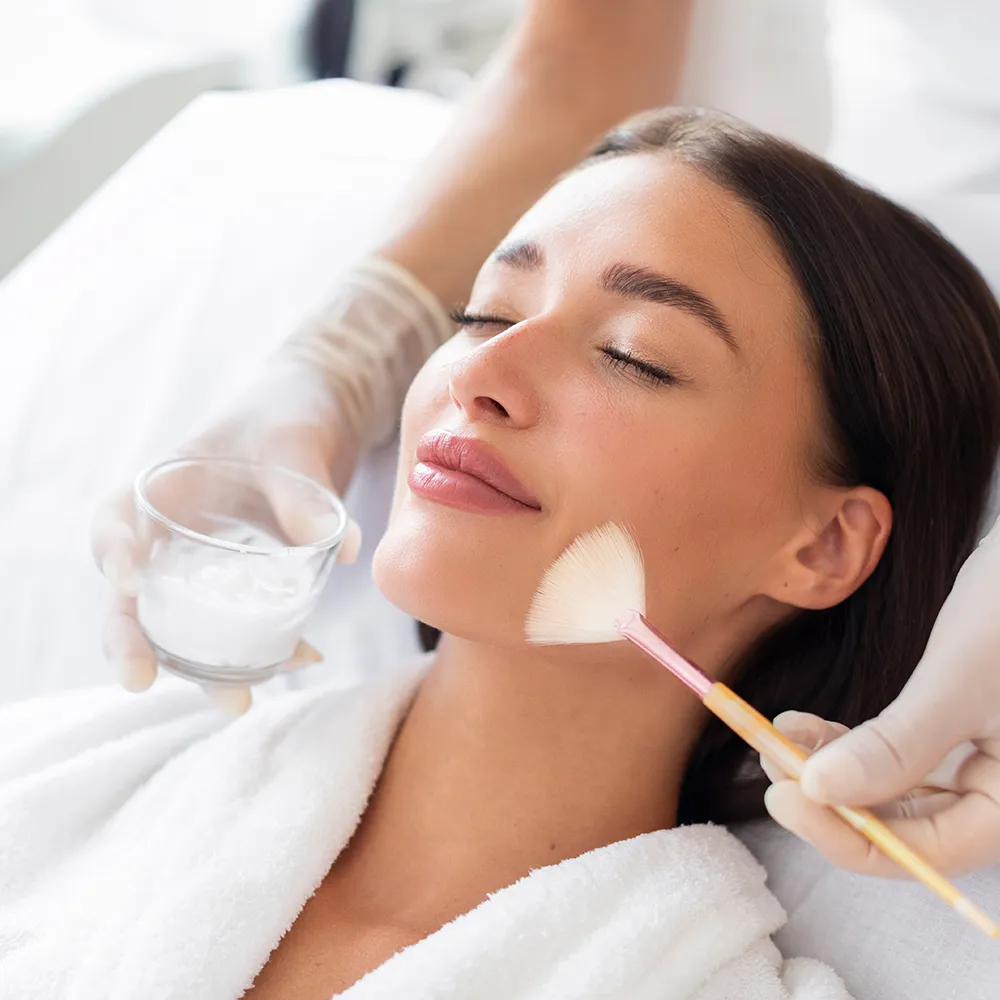 A woman receiving a chemical peel at a cosmetic treatment.