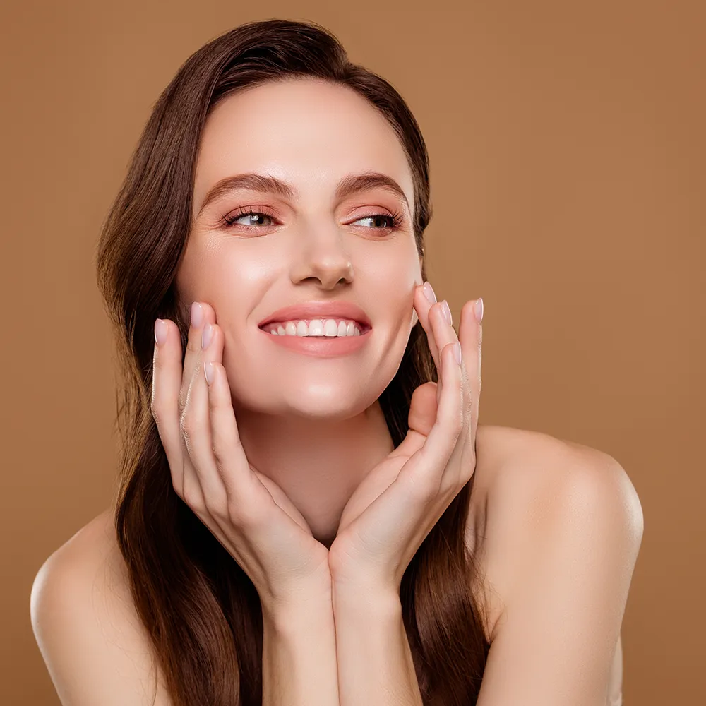 Close-up of a woman touching the skin on her face.