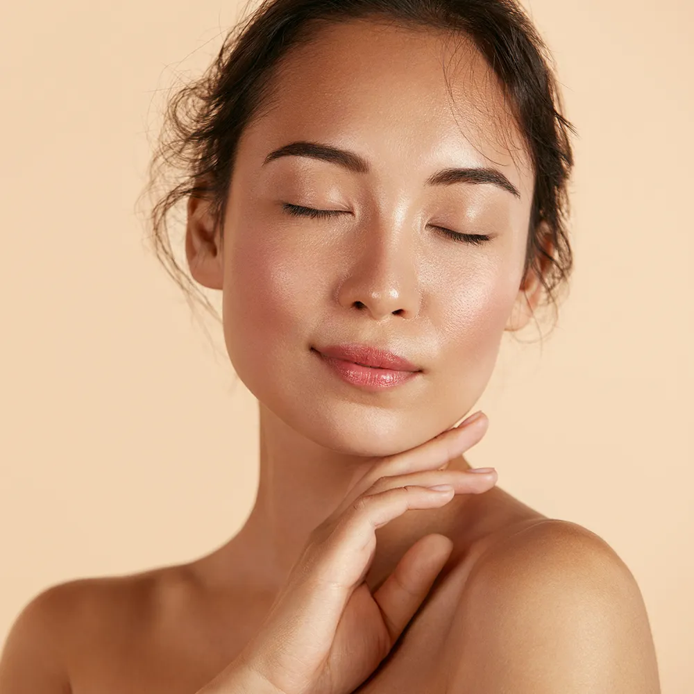 A woman posing with closed eyes, showcasing her face.
