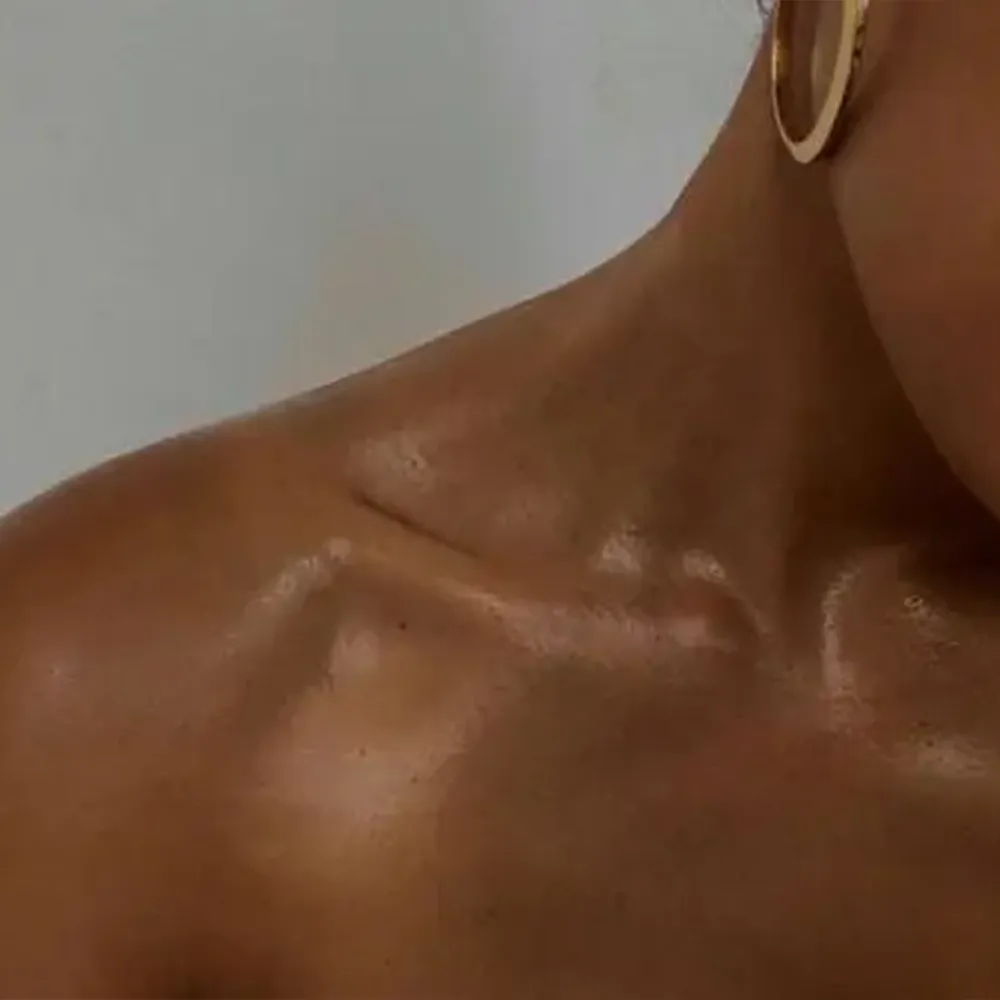 Close-up of a woman showing her clavicle.